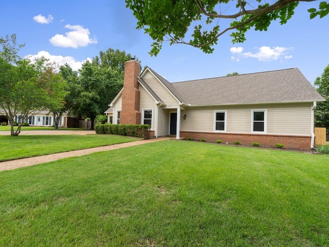 712 Lawncrest Cv, Collierville, TN 38017 - view of front facade with a chimney, a front yard, brick siding, and a shingled roof
