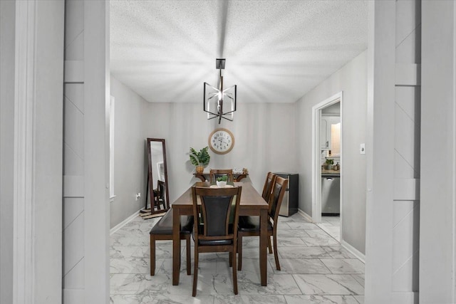 3266 Dothan St, Memphis, TN 38118 - dining area with light marble finish flooring, a chandelier, a textured ceiling, and baseboards