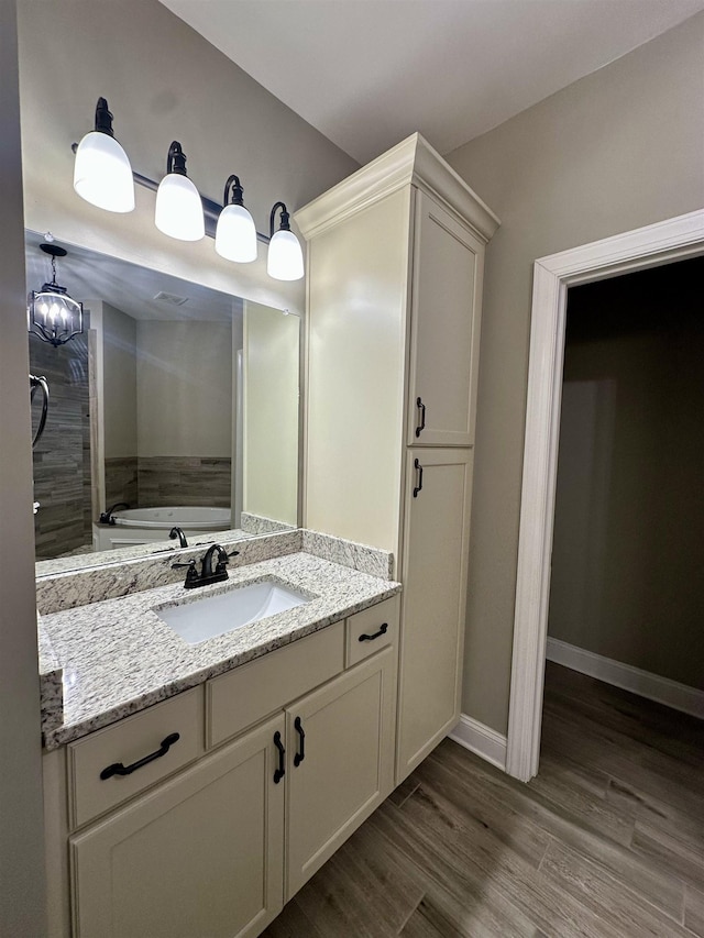 4049 Courtyard Dr, Southaven, MS 38672 - bathroom with vanity, wood finished floors, a bath, and baseboards