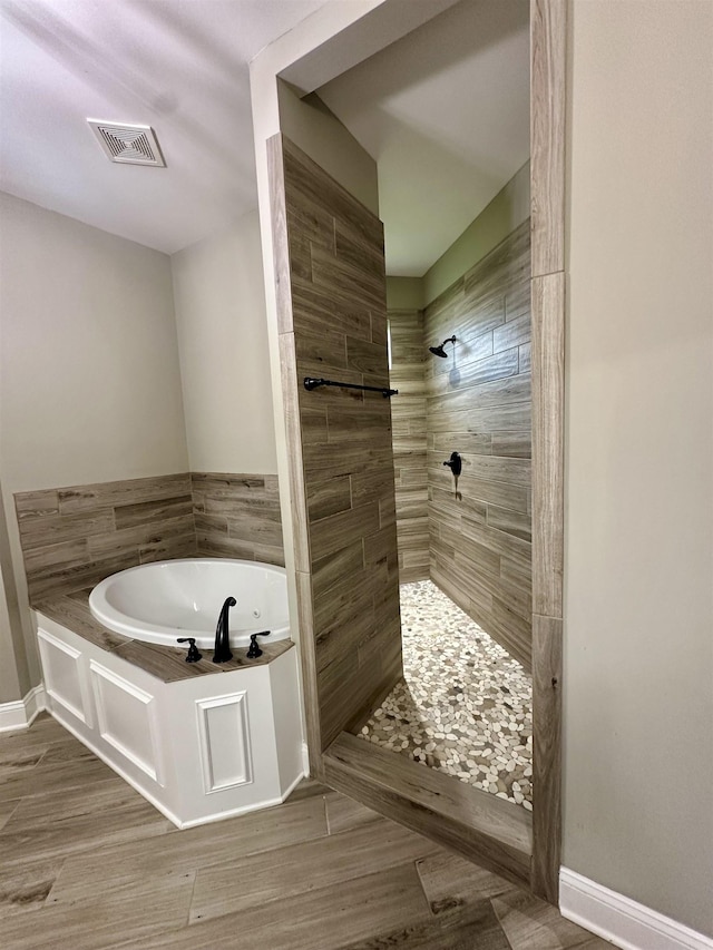 4049 Courtyard Dr, Southaven, MS 38672 - bathroom with a bath, a tile shower, wood finished floors, and baseboards
