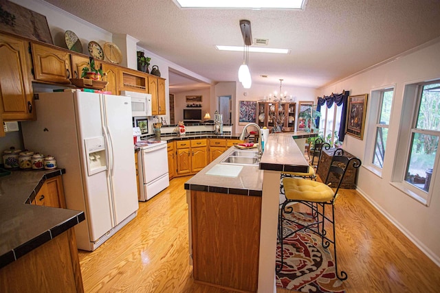 67 Walker Field Ln, Munford, TN 38058 - kitchen featuring white appliances, a sink, a peninsula, light wood-style floors, and a chandelier