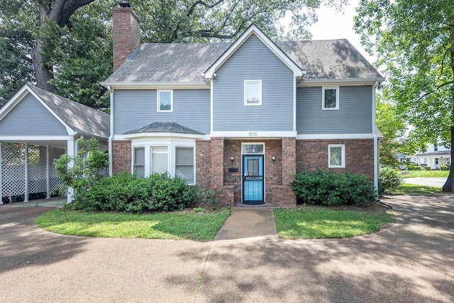 1570 Eastmoreland Ave, Memphis, TN 38104 - view of front of house featuring a chimney, brick siding, a carport, and a shingled roof