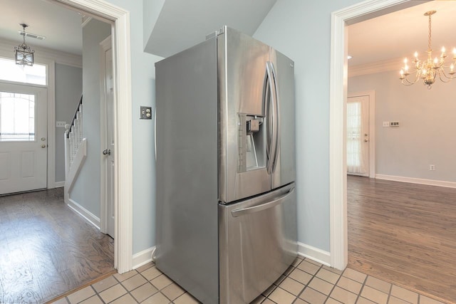 1570 Eastmoreland Ave, Memphis, TN 38104 - kitchen featuring stainless steel fridge with ice dispenser, a chandelier, crown molding, light wood-style floors, and baseboards