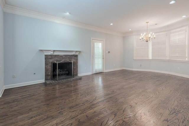 1570 Eastmoreland Ave, Memphis, TN 38104 - unfurnished living room featuring crown molding, a chandelier, a brick fireplace, dark wood-style floors, and recessed lighting