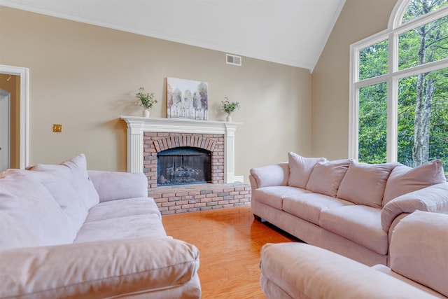 2660 Dibrell Trail Dr, Collierville, TN 38017 - living room with ornamental molding, vaulted ceiling, a brick fireplace, and wood finished floors