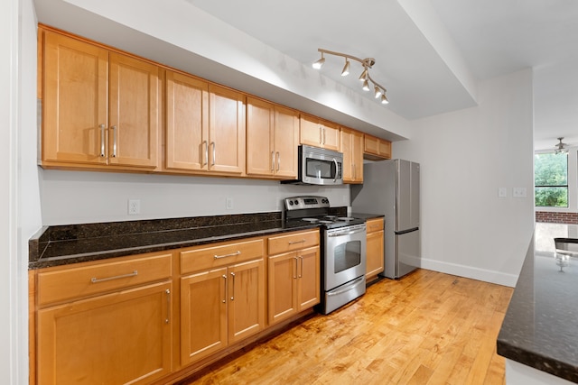 123 Court Ave Unit 401, Memphis, TN 38103 - kitchen with stainless steel appliances, light wood-style floors, dark stone counters, and baseboards