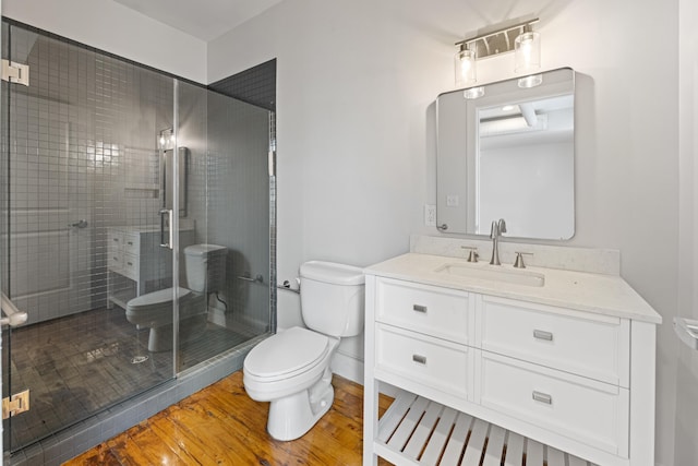 123 Court Ave Unit 401, Memphis, TN 38103 - full bathroom featuring toilet, vanity, wood finished floors, and a stall shower