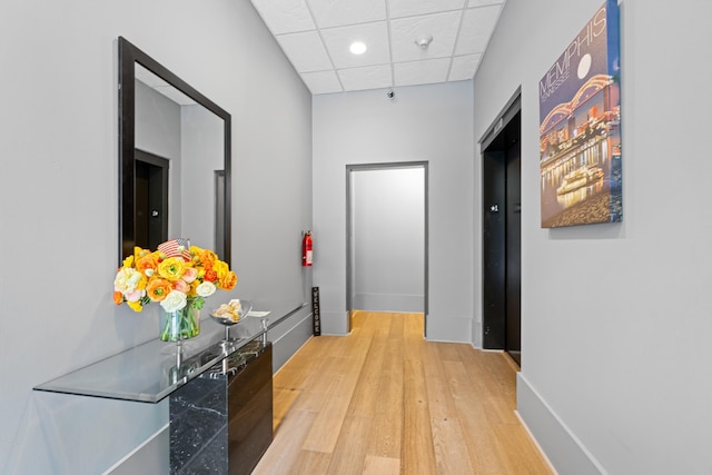 123 Court Ave Unit 401, Memphis, TN 38103 - hall featuring light wood-type flooring, a drop ceiling, recessed lighting, baseboards, and elevator