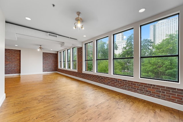 123 Court Ave Unit 401, Memphis, TN 38103 - spare room with brick wall, light wood-style flooring, healthy amount of natural light, baseboards, and ceiling fan