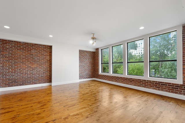 123 Court Ave Unit 401, Memphis, TN 38103 - empty room featuring brick wall, plenty of natural light, wood finished floors, baseboards, and recessed lighting