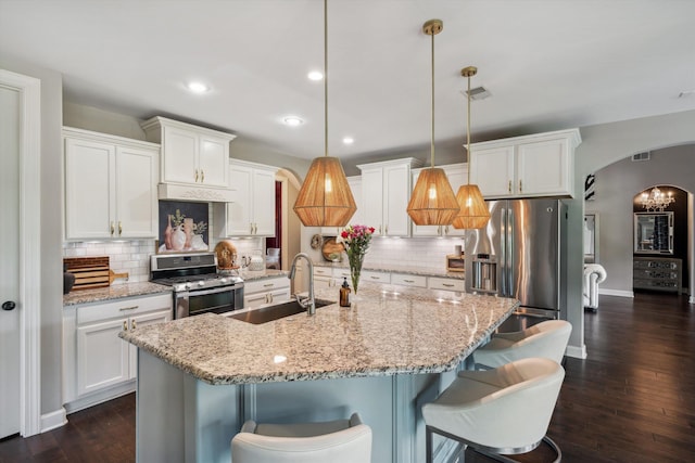 125 Mallard Ln, Rossville, TN 38066 - kitchen with stainless steel appliances, a sink, arched walkways, white cabinets, and dark wood-style floors