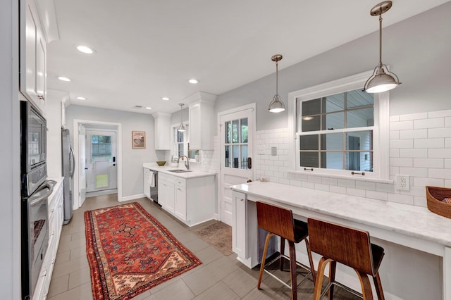 5543 Walnut Grove Rd, Memphis, TN 38120 - kitchen featuring a sink, stainless steel appliances, decorative backsplash, white cabinetry, and recessed lighting