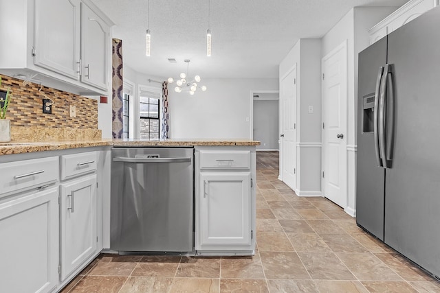 4788 Shadow View Ln, Bartlett, TN 38002 - kitchen featuring stainless steel appliances, a chandelier, backsplash, a peninsula, and light stone finish floors