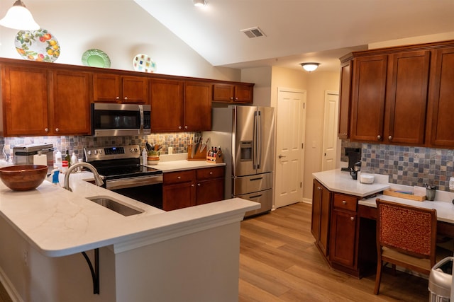 301 Stonevillage Dr W Unit 51, Collierville, TN 38017 - kitchen with appliances with stainless steel finishes, light countertops, a sink, lofted ceiling, and a peninsula