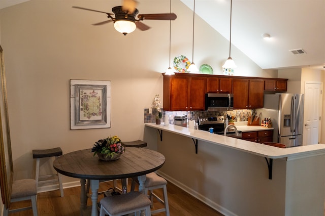 301 Stonevillage Dr W Unit 51, Collierville, TN 38017 - kitchen featuring stainless steel appliances, high vaulted ceiling, a breakfast bar, tasteful backsplash, and dark wood finished floors