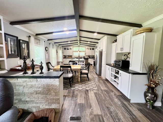 2045 Hardin Graveyard Rd, Adamsville, TN 38310 - kitchen featuring dark countertops, dark wood-style flooring, a textured ceiling, healthy amount of natural light, and freestanding refrigerator