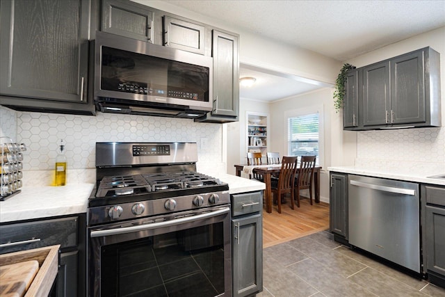 1159 Echles St, Memphis, TN 38111 - kitchen with appliances with stainless steel finishes, light countertops, decorative backsplash, and tile patterned floors