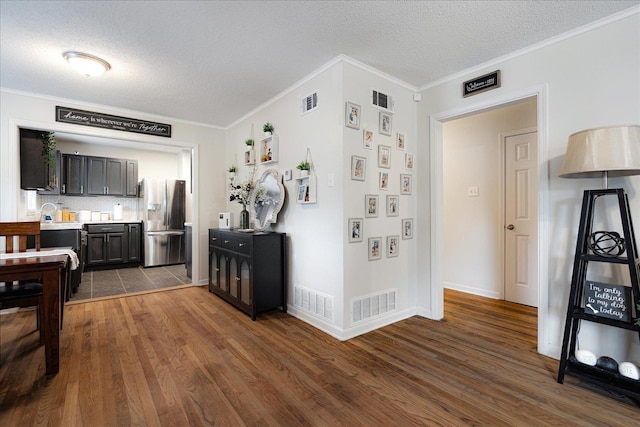 1159 Echles St, Memphis, TN 38111 - kitchen with stainless steel refrigerator with ice dispenser, dark wood-type flooring, ornamental molding, light countertops, and a textured ceiling