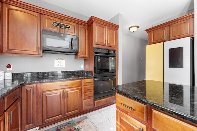 420 Estanaula Rd, Collierville, TN 38017 - kitchen featuring black appliances, dark stone counters, light tile patterned flooring, and brown cabinetry