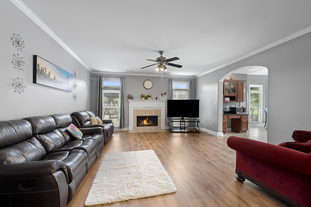 420 Estanaula Rd, Collierville, TN 38017 - living area featuring crown molding, light wood-style floors, arched walkways, ceiling fan, and a fireplace with flush hearth