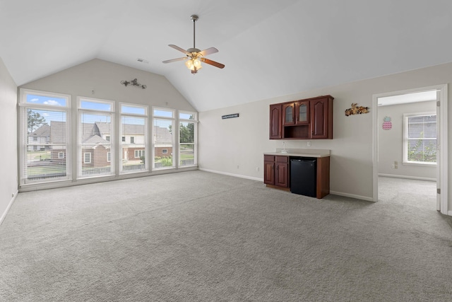 420 Estanaula Rd, Collierville, TN 38017 - unfurnished living room featuring baseboards, vaulted ceiling, a ceiling fan, light colored carpet, and bar area