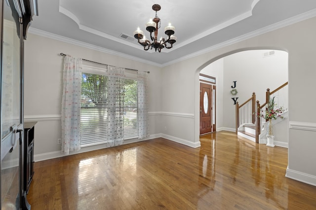 420 Estanaula Rd, Collierville, TN 38017 - empty room with arched walkways, a chandelier, wood finished floors, a raised ceiling, and stairs