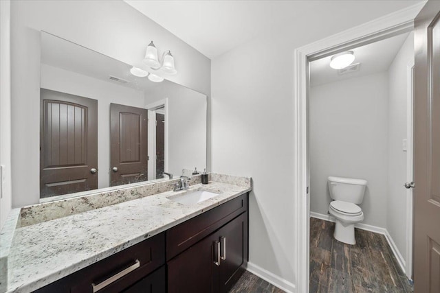 6159 Upper Granger St, Arlington, TN 38002 - bathroom featuring vanity, toilet, wood finished floors, and baseboards