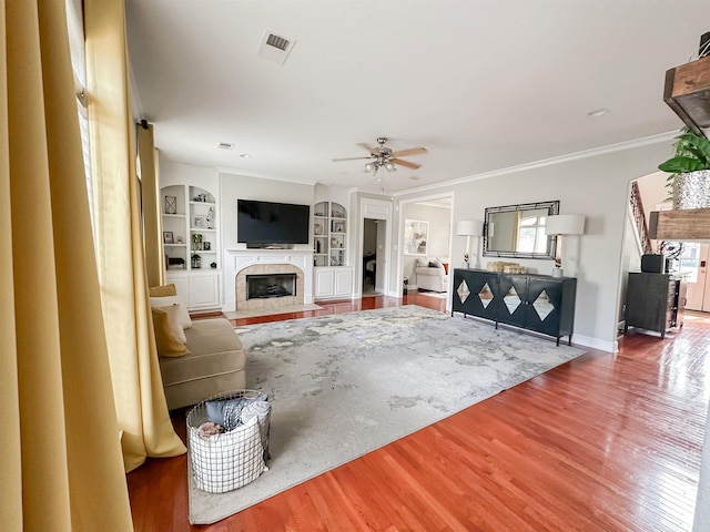 1400 Stable Run Dr, Cordova, TN 38016 - living room with a fireplace with flush hearth, a ceiling fan, crown molding, wood finished floors, and built in shelves