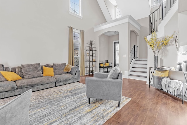 7415 Lost Grove Ln, Cordova, TN 38016 - living room with arched walkways, a high ceiling, stairway, and wood finished floors