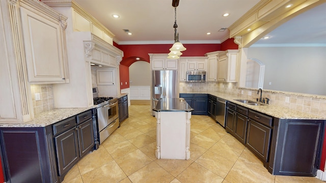 4111 Sir Thopas Dr, Southaven, MS 38671 - kitchen with appliances with stainless steel finishes, arched walkways, a center island, backsplash, and a wainscoted wall