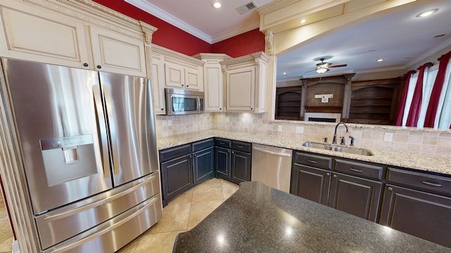 4111 Sir Thopas Dr, Southaven, MS 38671 - kitchen featuring appliances with stainless steel finishes, cream cabinetry, ceiling fan, light tile patterned floors, and tasteful backsplash