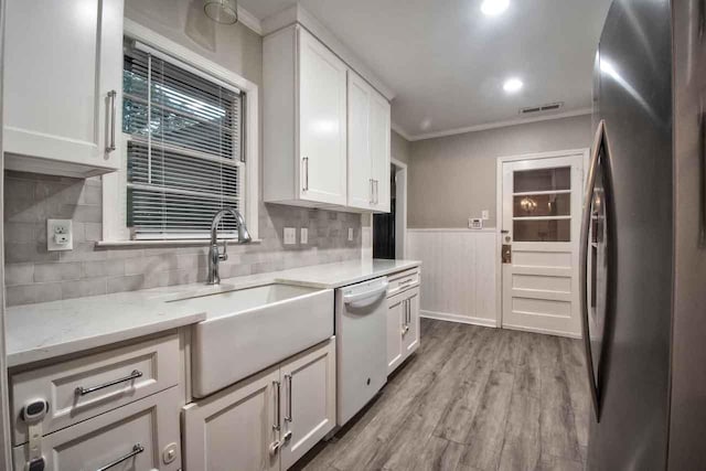 4737 Sequoia Ave, Memphis, TN 38117 - kitchen with dishwasher, freestanding refrigerator, crown molding, white cabinetry, and light wood-type flooring