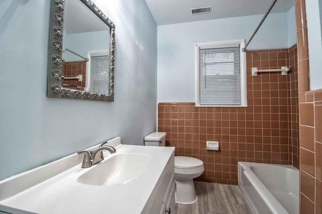 4737 Sequoia Ave, Memphis, TN 38117 - full bath featuring tile walls, vanity, tub / shower combination, wood finished floors, and a wainscoted wall