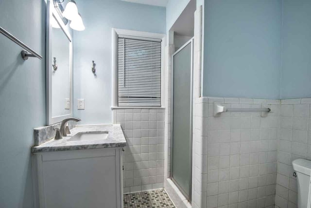 4737 Sequoia Ave, Memphis, TN 38117 - bathroom featuring tile walls, a stall shower, vanity, and a wainscoted wall