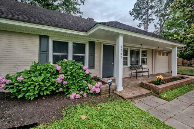4737 Sequoia Ave, Memphis, TN 38117 - property entrance with covered porch, brick siding, roof with shingles, and a chimney