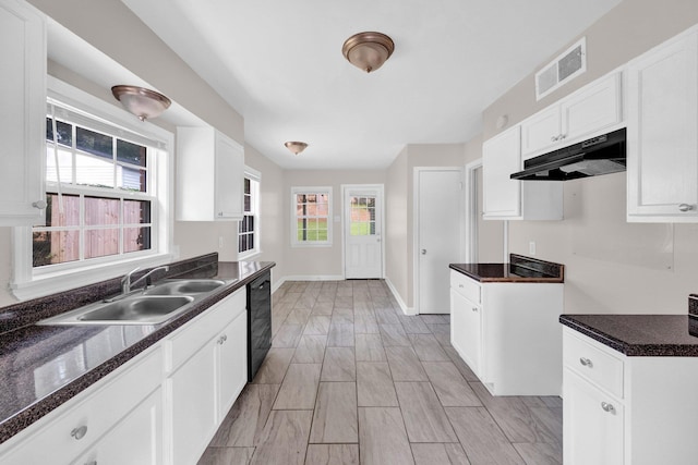 3051 Overbrook Dr, Memphis, TN 38128 - kitchen with under cabinet range hood, black dishwasher, and white cabinetry