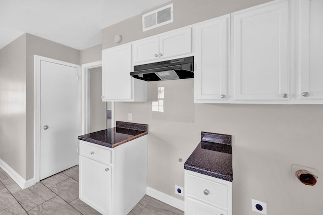 3051 Overbrook Dr, Memphis, TN 38128 - kitchen featuring under cabinet range hood, white cabinetry, light marble finish floors, and dark stone countertops