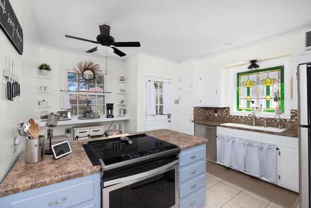 1856 N Rainbow Dr, Memphis, TN 38107 - kitchen featuring appliances with stainless steel finishes, a ceiling fan, healthy amount of natural light, ornamental molding, and white cabinets