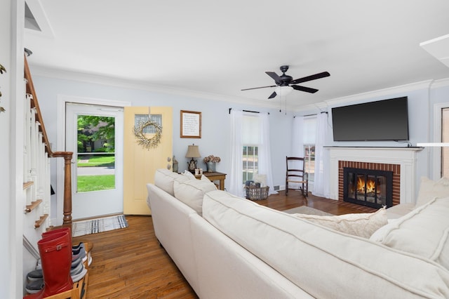 1856 N Rainbow Dr, Memphis, TN 38107 - living room with wood finished floors, a brick fireplace, ceiling fan, crown molding, and stairs