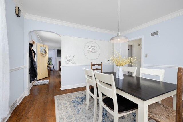 1856 N Rainbow Dr, Memphis, TN 38107 - dining space featuring crown molding, wood finished floors, and arched walkways