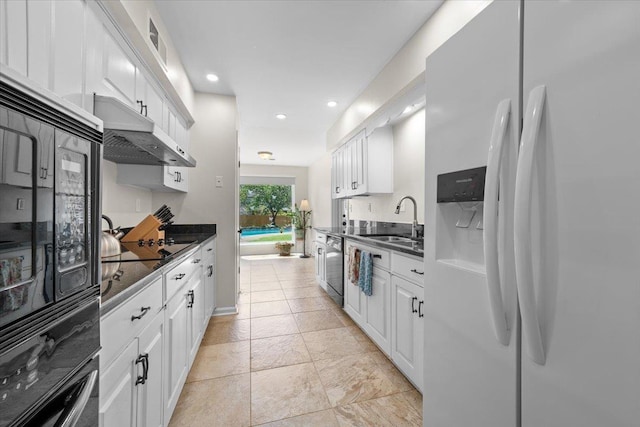 1469 Poplar Estates Pkwy, Germantown, TN 38138 - kitchen with white fridge with ice dispenser, dark countertops, under cabinet range hood, white cabinetry, and recessed lighting
