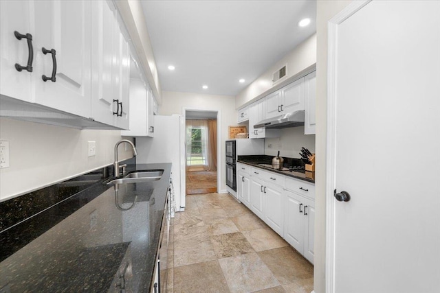 1469 Poplar Estates Pkwy, Germantown, TN 38138 - kitchen with under cabinet range hood, white cabinetry, recessed lighting, stovetop, and dark stone counters