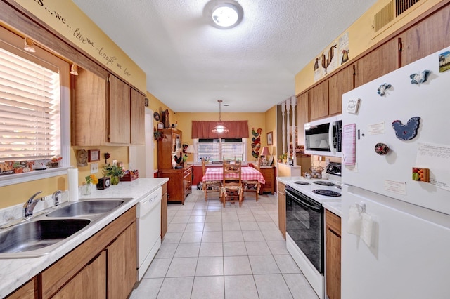 6385 Easthampton Cv, Bartlett, TN 38134 - kitchen with white appliances, light countertops, plenty of natural light, a textured ceiling, and light tile patterned flooring