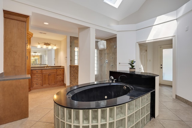 236 Riveredge Cv, Memphis, TN 38018 - bathroom with tile patterned floors, a tub with jets, walk in shower, vanity, and vaulted ceiling
