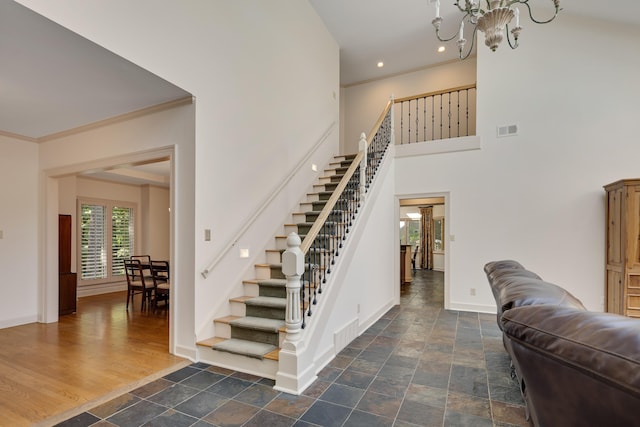 236 Riveredge Cv, Memphis, TN 38018 - staircase featuring recessed lighting, stone finish flooring, a chandelier, a towering ceiling, and crown molding