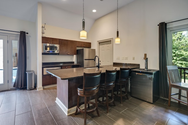 236 Riveredge Cv, Memphis, TN 38018 - kitchen featuring stainless steel appliances, dark countertops, a peninsula, a kitchen breakfast bar, and decorative light fixtures