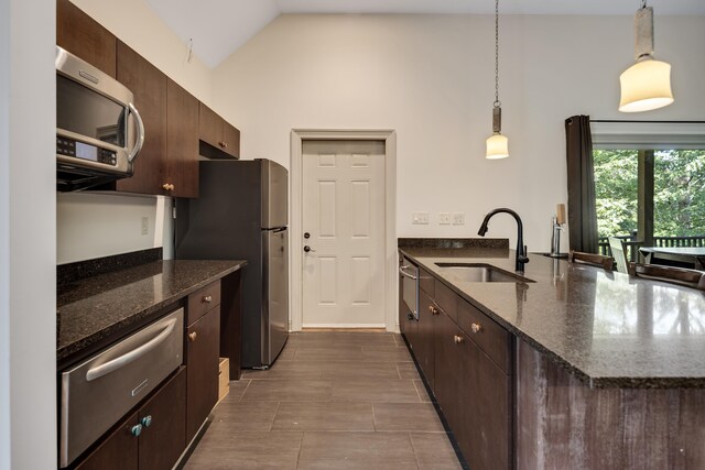 236 Riveredge Cv, Memphis, TN 38018 - kitchen featuring stainless steel appliances, a warming drawer, a peninsula, dark brown cabinets, and dark stone counters