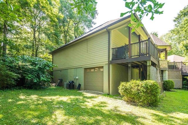 236 Riveredge Cv, Memphis, TN 38018 - back of house featuring a garage, a yard, a deck, and roof with shingles