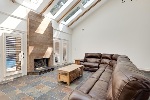 236 Riveredge Cv, Memphis, TN 38018 - living area featuring a skylight, high vaulted ceiling, stone tile floors, and a high end fireplace