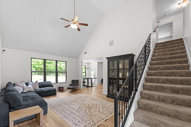 691 Rocky Field Cv, Memphis, TN 38018 - living room featuring stairs, high vaulted ceiling, wood finished floors, plenty of natural light, and a chandelier